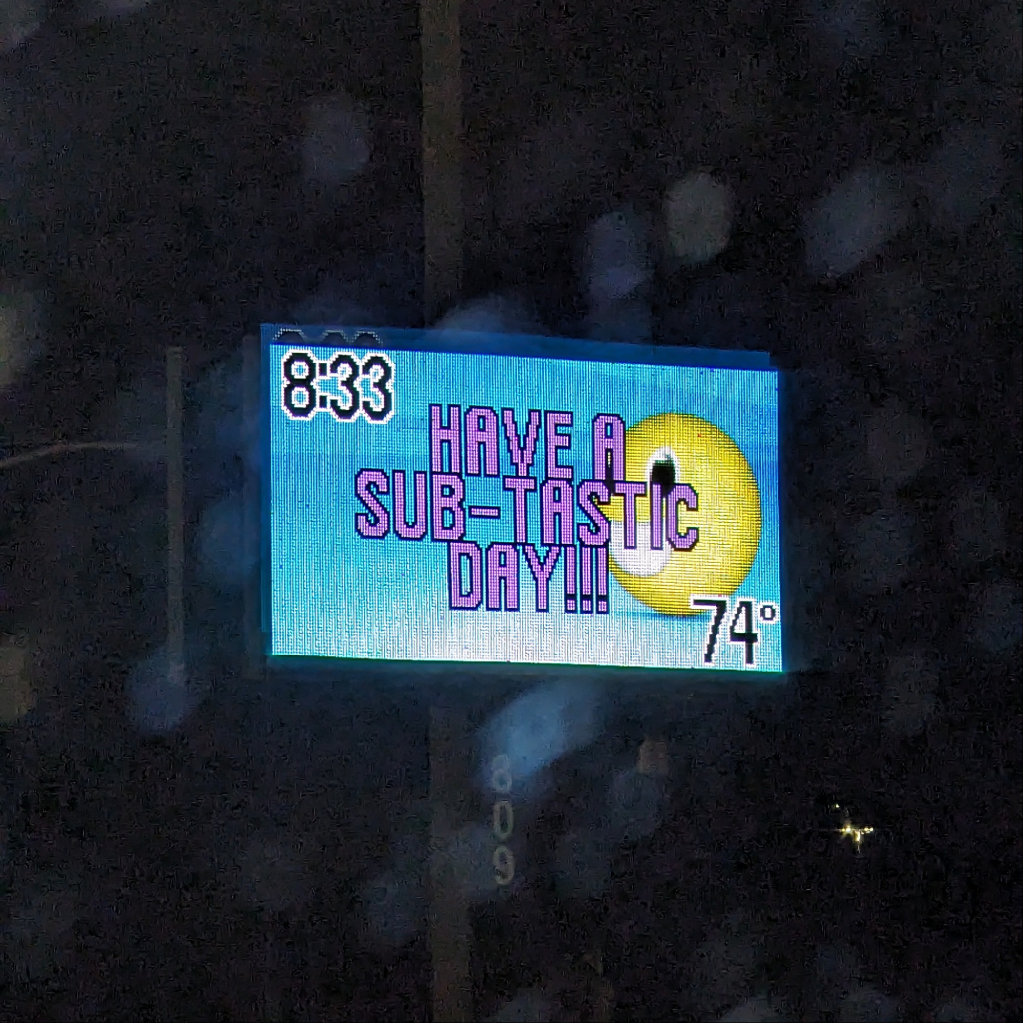 LED sign with blue backhround, smiley face on right, and pink text reading "Have a Sub-tastic Day!!!"