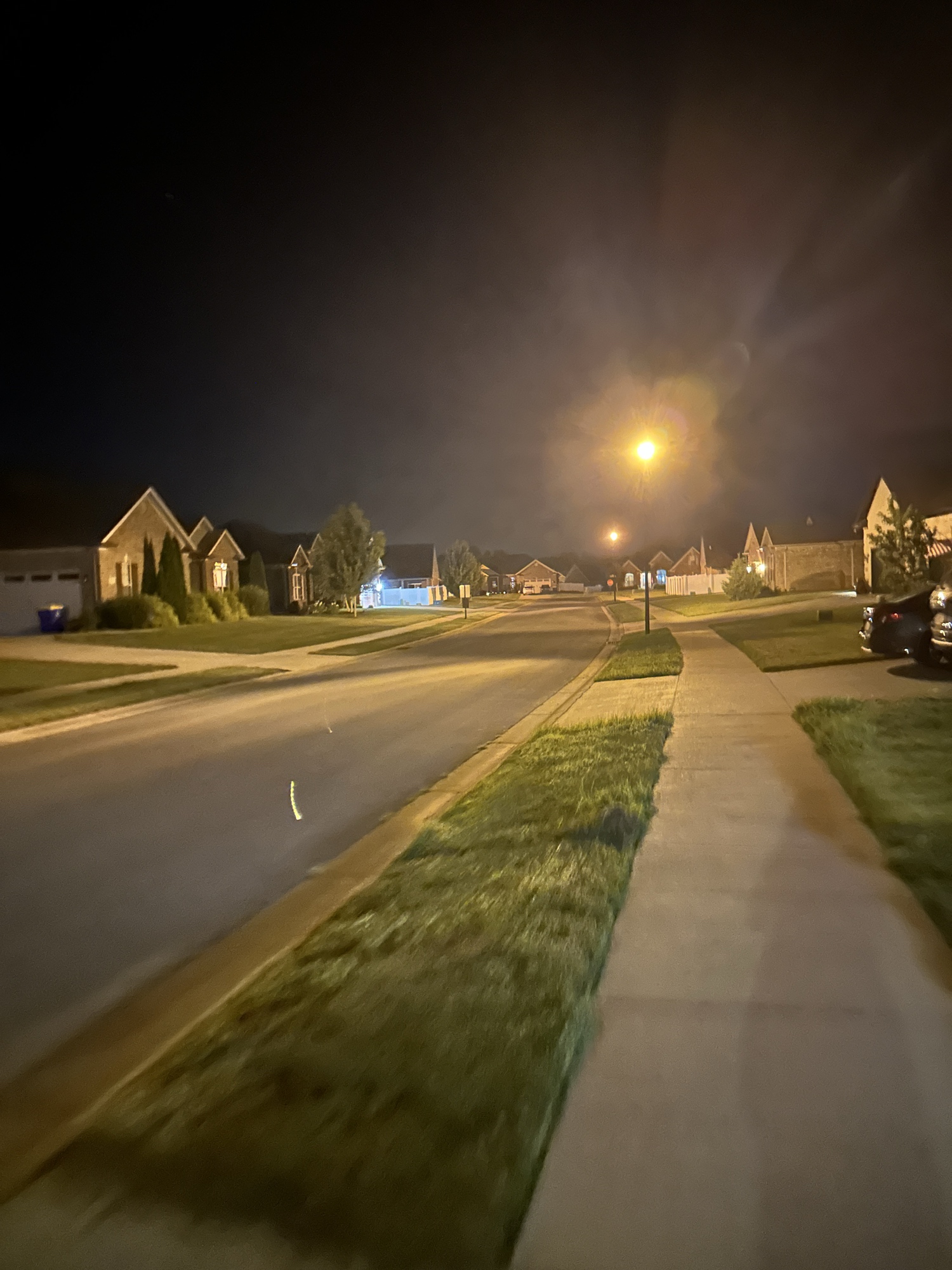 a slightly blurry photo of a super boring suburban neighborhood at night
