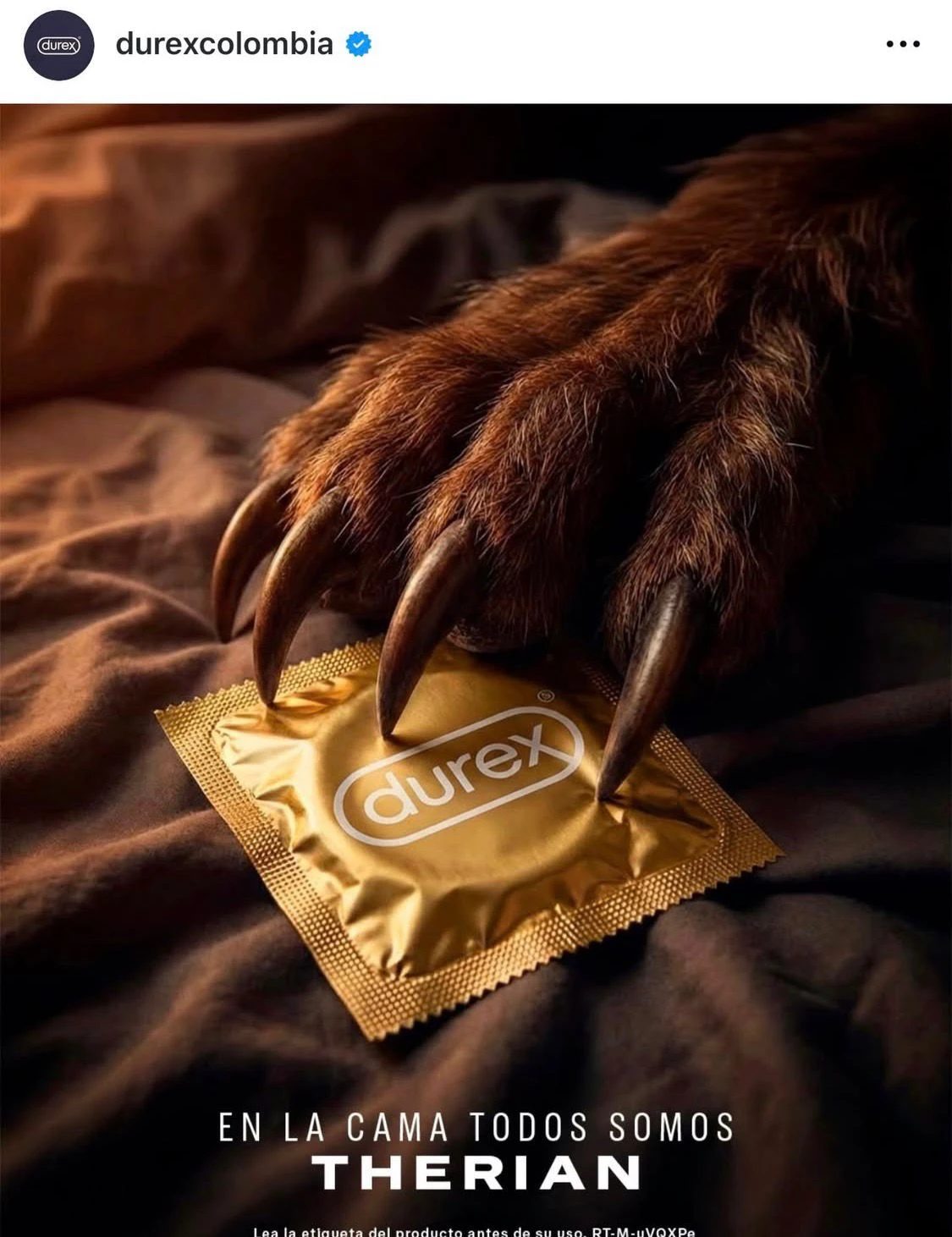 Instagram post from @durexcolombia. A furry werewolf hand rests on rumpled brown sheets, sharp claws resting on a gold Durex condom wrapper. Text below reads: "EN LA CAMA TODOS SOMOS THERIAN" ("In bed, we are all therians"). Small print at the bottom reads: "Lea la etiqueta del producto antes de su uso."